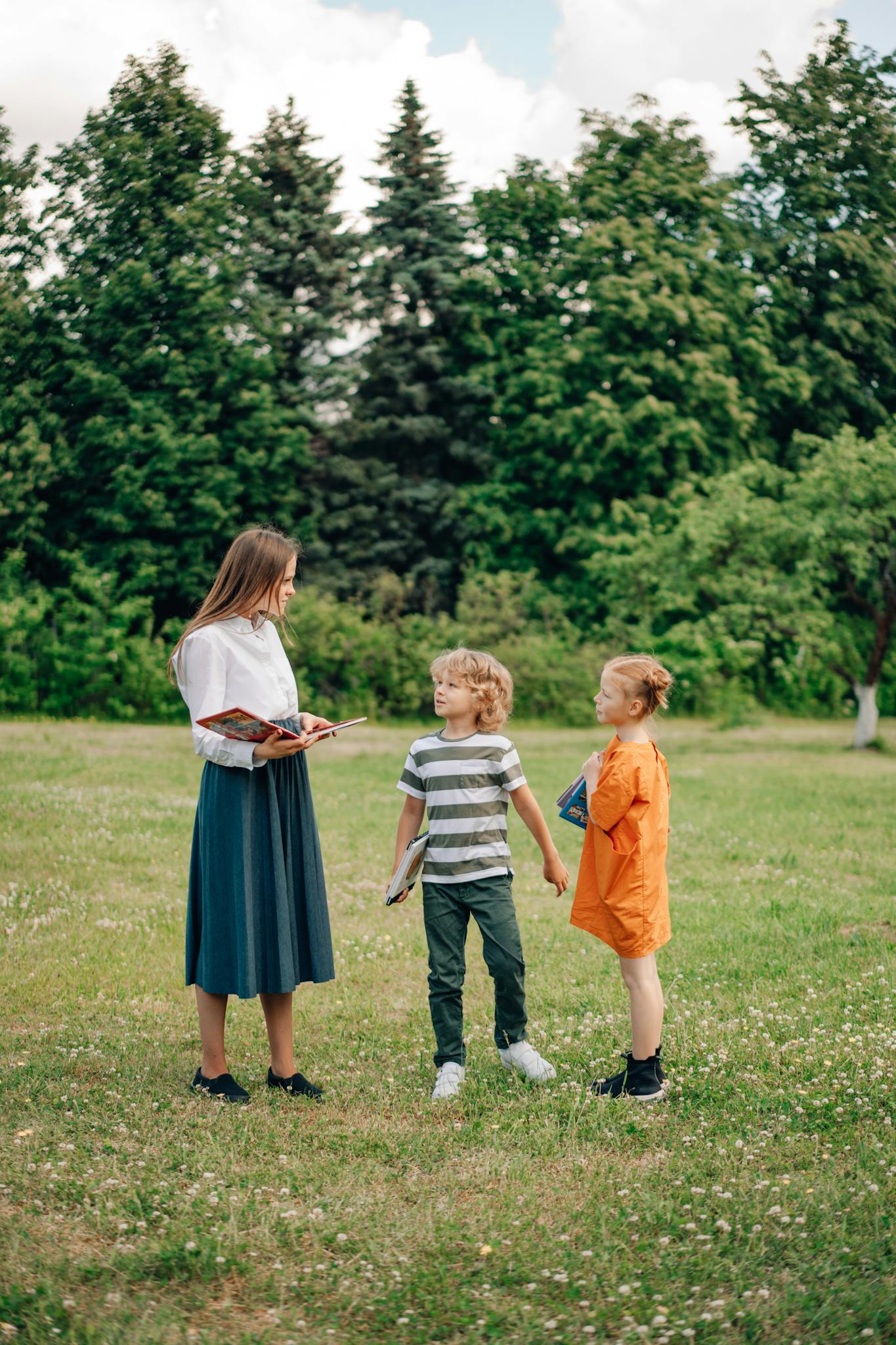 A teacher interacting with children outdoors, fostering learning in a natural setting.