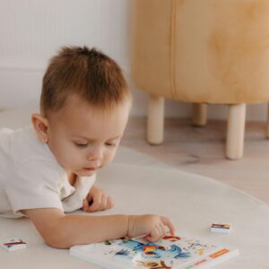 A young child exploring an educational picture book indoors, fostering early learning and curiosity.