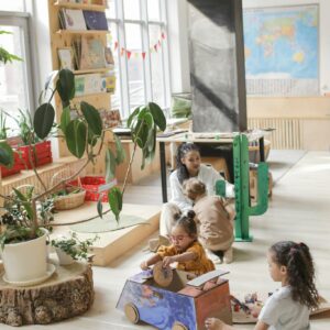 Children engaged in creative play in a well-lit classroom with educational materials.